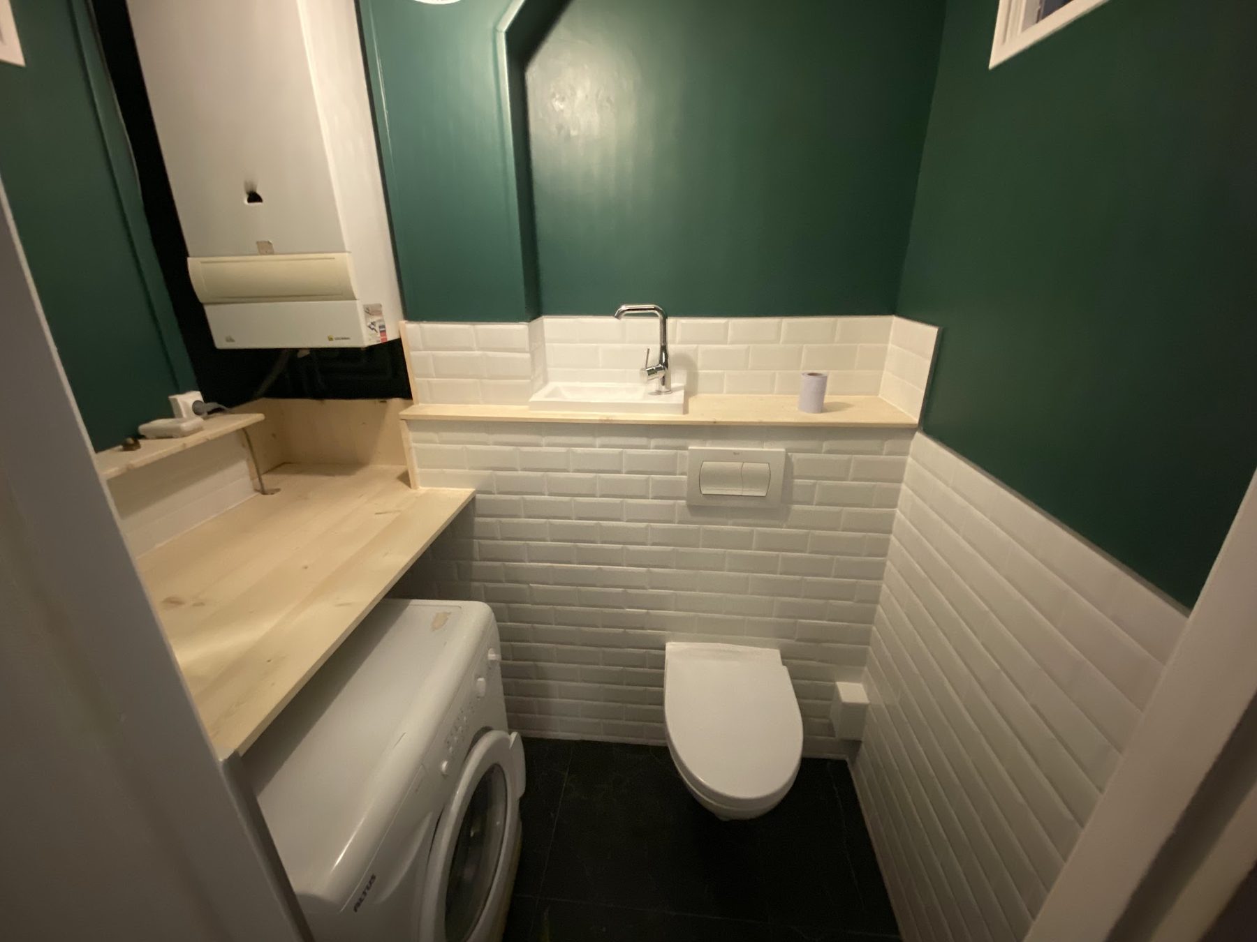 WC avec faïence métro blanche à mi-hauteur et mur vert